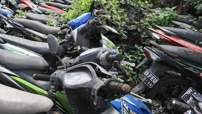 Petugas Kepolisian menunjukkan sepeda motor terbengkalai di kantor Laka Lantas Polres Metro Bekasi, Cikarang, Kabupaten Bekasi, Jawa Barat, Kamis (14/7/2022). Sebanyak ribuan motor bekas kecelakaan, sitaan dan hasil tindak kejahatan dari tahun 2004 berada di penampungan ini dan belum diambil pemiliknya. ANTARA FOTO/ Fakhri Hermansyah