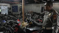 Petugas kepolisian menunjukkan sepeda motor yang ditampung di kantor Laka Lantas Polres Metro Bekasi, Cikarang, Kabupaten Bekasi, Jawa Barat, Kamis (14/7/2022).