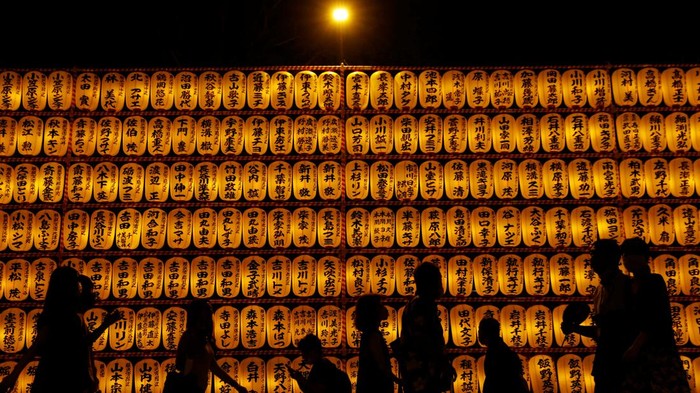 Women in yukata, or casual summer kimonos, wearing protective masks amid the coronavirus disease (COVID-19) outbreak, look around lanterns during the annual Mitama Festival at the Yasukuni Shrine, where more than 2.4 million war dead are enshrined, in Tokyo, Japan, July 13, 2022. REUTERS/Kim Kyung-Hoon TPX IMAGES OF THE DAY