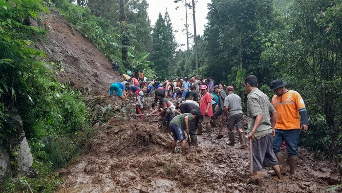 Petugas membersihkan longsor yang memutus akses jalan di Cilongok Banyumas, Kamis (14/7/2022).