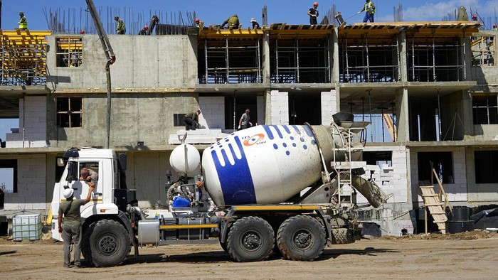 Rusia Langsung Bangun Apartemen hingga Rumah Sakit di Mariupol, Ukraina Construction workers work on the site of a new apartment building which is building with support of Russia Defense Ministry in Mariupol, on the territory which is under the Government of the Donetsk People's Republic control, eastern Ukraine, Wednesday, July 13, 2022. This photo was taken during a trip organized by the Russian Ministry of Defense. (AP Photo)