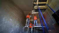 Sejumlah pekerja konstruksi tengah menyelesaikan pembangunan gedung apartemen.