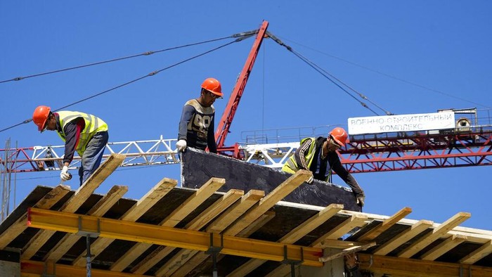 Construction workers work on the site of a new apartment building which is building with support of Russia Defense Ministry in Mariupol, on the territory which is under the Government of the Donetsk Peoples Republic control, eastern Ukraine, Wednesday, July 13, 2022. This photo was taken during a trip organized by the Russian Ministry of Defense. (AP Photo)