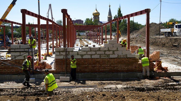 Construction workers work on the site of a new apartment building which is building with support of Russia Defense Ministry in Mariupol, on the territory which is under the Government of the Donetsk People's Republic control, eastern Ukraine, Wednesday, July 13, 2022. This photo was taken during a trip organized by the Russian Ministry of Defense. (AP Photo)