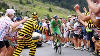 Sprinter tercepat, Wout Van Aert tak mau kalah di segmen tanjakan pada etape 11 Tour de France (TDF) 2022, Rabu (13/7/2022). Beberapakali ia mundur ke belakang untuk membantu rekannya menyerang Pogacar. (Alex Broadway/Getty Images)