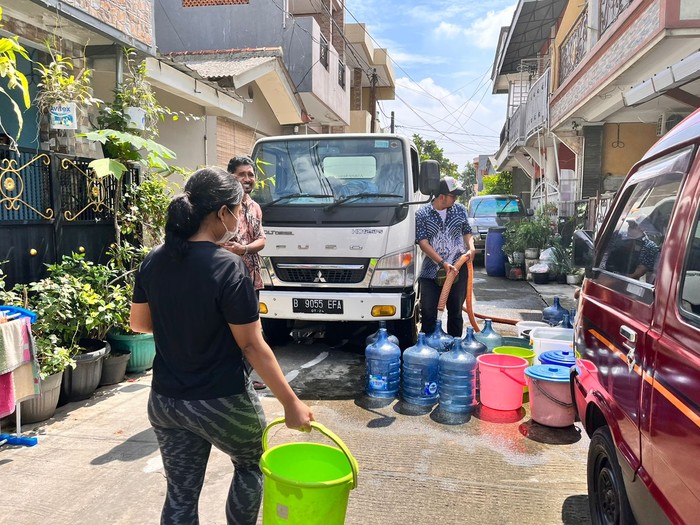 Warga Kompleks Marinir, Pancoranmas Depok mengantre air bersih dari tangki gegera gangguan air PAM, Kamis (14/7/2022).