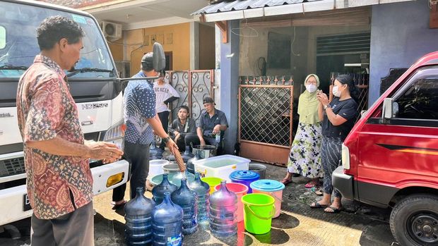 Warga Kompleks Marinir, Pancoranmas Depok mengantre air bersih dari tangki gegera gangguan air PAM, Kamis (14/7/2022).