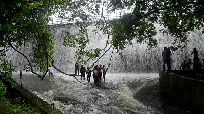 Bukannya Takut, Tumpahan Air dari Bendungan India Ini Malah Jadi Tempat Main Warga People enjoy the over flow water of Powai lake during heavy rainfall in Mumbai, India, 14 July, 2022. (Photo by Indranil Aditya/NurPhoto via Getty Images)