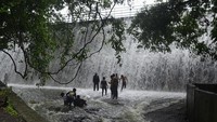 Tanpa rasa takut, warga asik menikmati aliran air bak air terjun ini.