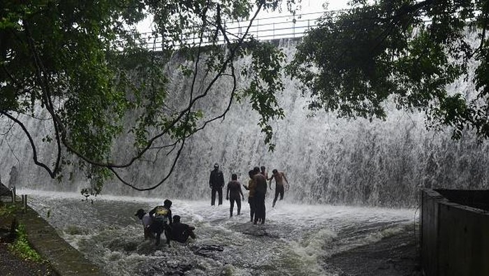 Bukannya Takut, Tumpahan Air dari Bendungan India Ini Malah Jadi Tempat Main Warga People enjoy the over flow water of Powai lake during heavy rainfall in Mumbai, India, 14 July, 2022. (Photo by Indranil Aditya/NurPhoto via Getty Images)