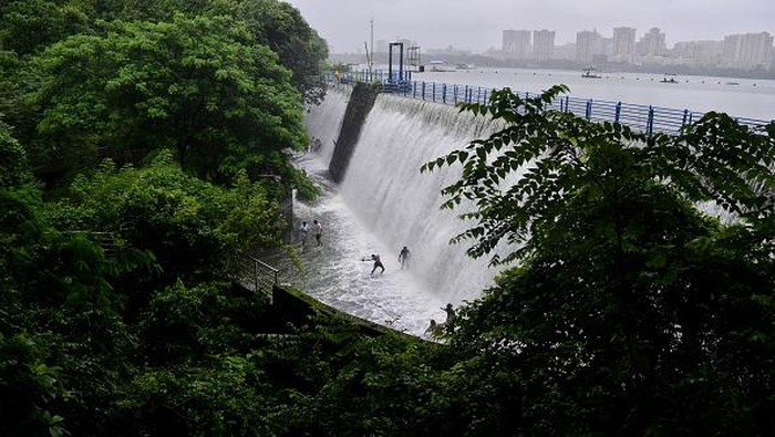 Bukannya Takut, Tumpahan Air dari Bendungan India Ini Malah Jadi Tempat Main Warga People enjoy the over flow water of Powai lake during heavy rainfall in Mumbai, India, 14 July, 2022. (Photo by Indranil Aditya/NurPhoto via Getty Images)