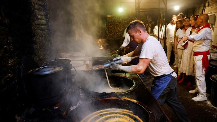 A worker pours dough into a large vat of frying oil to make traditional Spanish 'Churros' in the Eijalde family run 'Churreria La Manueta' in central Pamplona, Spain, July 12, 2022. REUTERS/Juan Medina