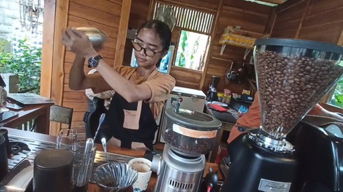 Dewi Syawal Sari, barista perempuan di Dadi Incore Coffee saat meramu kopi yang dipesan pengunjung, Jumat (15/7/2022)
