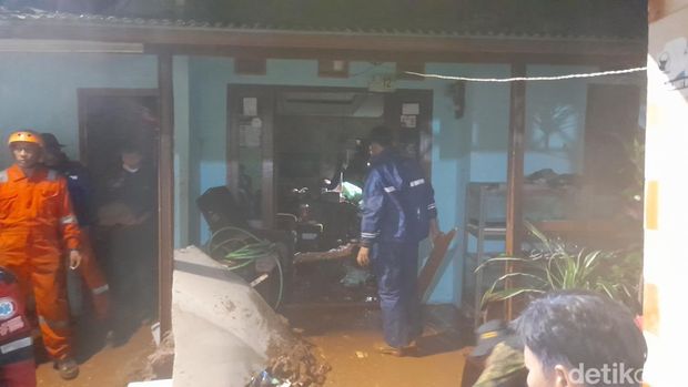 Hujan deras mengakibatkan dinding rumah warga di Kelurahan Curug, Kota Bogor ambrol. Seorang wanita tertimbun dan masih dalam proses evakuasi. (M Sholihin/detikcom)