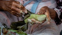 Tangan keriput Mbah Satinem dengan cekatan membuka daun pembungkus kue lupis buatannya.