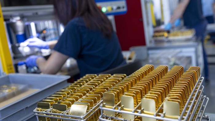 A staff takes a sample of melted gold out of a smelter into a mould of a bar at a plant of gold and silver refiner and bar manufacturer Argor-Heraeus in Mendrisio, Switzerland, July 13, 2022. REUTERS/Denis Balibouse