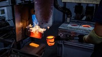 Emas cair mengalir keluar dari peleburan ke dalam cetakan untuk membentuk satu kilogram batangan emas.