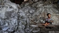 Anak kecil bermain di samping tumpukan sampah di kolong tol. Anak kecil bermain di samping tumpukan sampah di kolong tol.