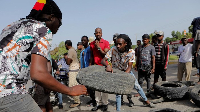 People push a car after running out of petrol as anger mounted over fuel shortages that have intensified as a result of gang violence, in Port-au-Prince, Haiti, July 13, 2022. REUTERS/Ralph Tedy Erol REFILE - QUALITY REPEAT