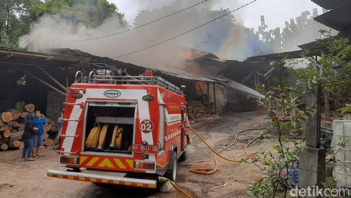 Petugas saat berupaya memadamkan api yang menghanguskan pengolahan oven kayu jati di Kalurahan Bangunjiwo, Kasihan, Bantul, Jumat (15/7/2022).