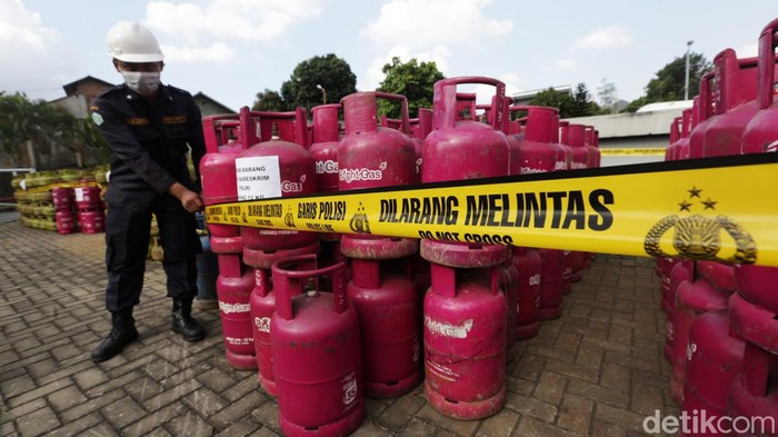 Petugas kepolisian mengamankan 3.344 tabung gas oplosan di Jakarta Timur, Jumat (15/7/2022). Direktorat Tindak Pindana Tertentu Bareskrim Polri mengungkap kasus penyalahgunaan lpg bersubsidi dengan modus menyuntikkan gas 3 kg bersubsidu ke tabung gas berukuran 5,5 kg, 12 kg dan 50 kg yang dijual harga non subsidi.