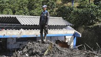 Seorang pria melihat proses evakuasi korban longsor yang dilakukan oleh warga setempat dan petugas penyelamat di kawasan Taparto, Kolombia.