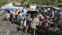 Petugas penyelamat dan warga setempat bahu membahu mengevakuasi korban longsor yang tertimbun di sebuah bangunan sekolah yang berada di kawasan Taparto, Kolombia, Kamis (14/7/2022) waktu setempat.