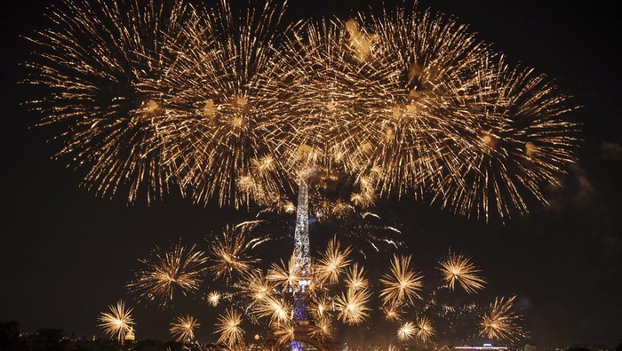 Perayaan Bastille Day di Paris, Prancis, dimeriahkan pesta kembang api. Menara Eiffel tampak bermandikan cahaya warna-warni dari pesta kembang api tersebut.