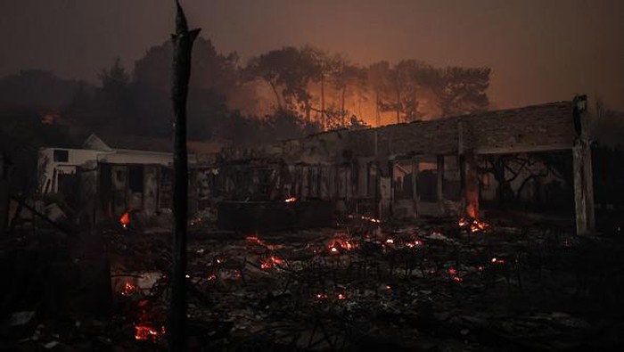 Restoran Ini Hancur Dilalap Kebakaran Hutan di Prancis A firefighter spreads water as a wildfire extends in the area close to the beach of Cazaux lac, near La Teste-de-Buch, southwestern France, on July 15, 2022. - In a context of strong heat on the southern half of the country, the firemen still face two aggressive forest fires in Gironde, with more than 5.000 hectares burned and more than 10.000 people evacuated since July 12, 2022, and fight from now on a