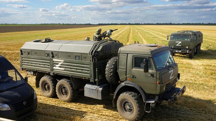 A Russian soldier atop of a military truck guards an area during foreign journalists watch and film as farmers of the Voznesenka-Agro farm harvest with their combine in a wheat field not far from Melitopol, south Ukraine, Thursday, July 14, 2022. About 300,000 tonnes of harvest have been collected in Melitopol district of Zaporizhzhia region. Russia took control of part of the Zaporizhzhia region quickly after the launch of the military operation in Ukraine. This photo was taken during a trip organized by the Russian Ministry of Defense. (AP Photo)