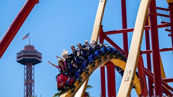 Orang-orang menaiki roller coaster Wonder Woman Flight of Courage yang baru diresmikan di Six Flags Magic Mountain, Valencia, California, Amerika Serikat, Kamis (14/7/2022).