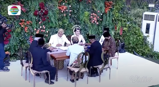 Via Vallen dan Chevra tampil serasi mengenakan busana pengantin adat Jawa berwarna putih. Setelah ijab kabul selesai diucapkan, Via dan Chevra kemudian dipertemukan dan bersama-sama mengurus dokumen-dokumen pernikahan. Foto: Indosiar