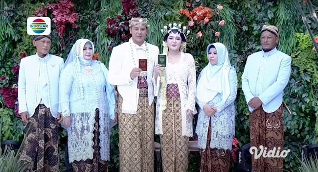 Busana yang dikenakan oleh Via Vallen dan Chevra saat akad nikah merupakan rancangan dari desainer Didiet Maulana. Begini penampilan Via dan Chevra saat berfoto bersama orangtua sambil memamerkan buku nikah. Foto: Indosiar