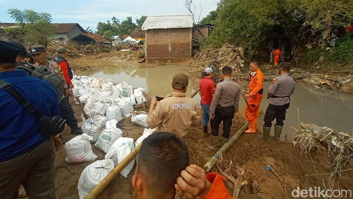 Warga bersama relawan gabungan memperbaiki tanggul Sungai Suatu yang jebol di Desa Bulumanis Kidul, Kecamatan Margoyoso, Jumat (15/7/2022).