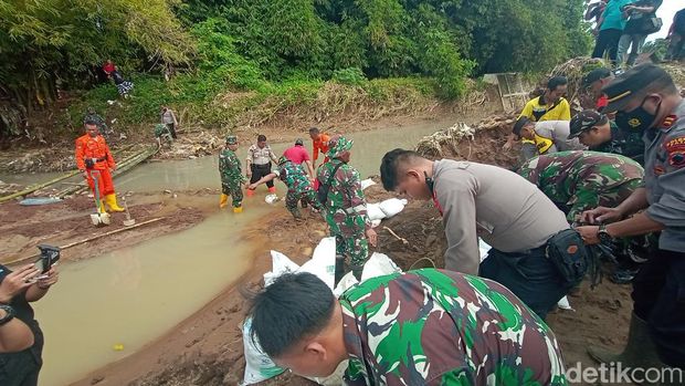 Warga bersama relawan memperbaiki tanggul Sungai Suatu yang jebol di Desa Bulumanis Kidul Kecamatan Margoyoso, Jumat (15/7/2022).
