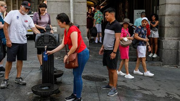 MADRID, SPAIN - JULY 14: People refill their water bottles at a fountain as they attempt to cool off at Plaza Mayor as temperatures continue to soar on July 14, 2022 in Madrid, Spain. Europe is currently experiencing the most sustained period of extreme hot weather in 50 years. (Photo by Pablo Blazquez Dominguez/Getty Images)