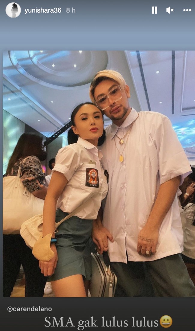 Kemeja putih yang dikenakan oleh Yuni Shara itu bagian bawahnya tampak dimasukkan ke dalam rok. Masing-masing lengan kemejanya digulung menjadi lebih pendek. Foto: Instagram