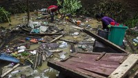 Warga mencari barang dan perabotan yang bisa diselamatkan dari rumahnya yang terendam banjir bandang Sungai Cimanuk di Garut, Jawa Barat, Sabtu (16/7/2022).