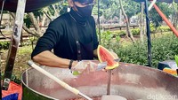 Syafril menjelaskan kalau semangka dicacah kecil, lalu dipindahkan ke baskom jumbo di gerobak. Semangka itu lalu ditambahkan air dan sirup merah homemade buatan Syafril, serta es batu.  Foto: detikFood/Yenny Mustika Sari