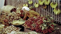 Cara berjualannya yakni dengan menggantungkan buah-buahan dagangannya ke pagar kayu. Selain itu, ada juga yang dijajakan pakai tampah. Foto: Lib.UWM - Forman Harrison