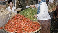 Foto ini memperlihatkan seorang wanita yang berbelanja cabai. Wanita itu tampak ingin membayar ke pedagang yang ia beli. Foto: Lib.UWM - Forman Harrison