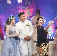 Senada dengan penampilan istrinya, Chevra Yolandi tampak gagah dengan setelan serba putih. Jas sepanjang di atas lutut sukses memancarkan auranya bak pangeran. (Foto: Dok. Humas Pemprov Jatim)