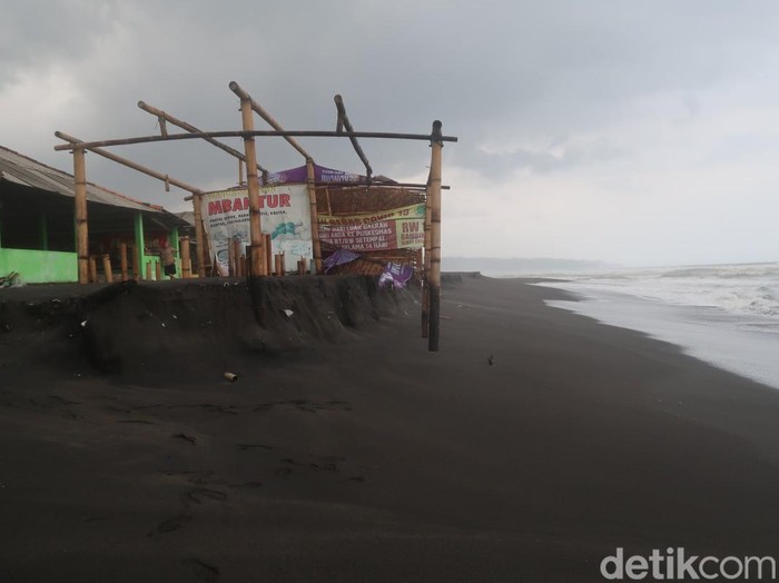 Kondisi Pantai Depok sisi timur, Bantul, usai diterjang gelombang pasang pada Sabtu (16/7/2022). Sejumlah warung semi permanen rusak.