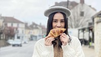 Liburan ke Paris, Anya tak lewatkan kulineran enak. Begini momen Anya Geraldine saat makan croissant dengan latar cantiknya kota Paris. Foto: Instagram @anyageraldine