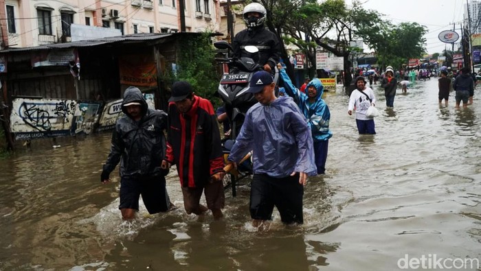 Pemotor Andalkan Ojek Gerobak untuk Terjang Banjir di Ciledug Banjir memutus akses Jalan KH Hasyim Ashari, Ciledug Indah, Tangerang, Sabtu (16/7). Pengendara sepeda motor pun memanfaatkan ojek gerobak untuk melintasi jalanan yang terendam banjir.