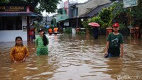 Sejumlah anak justru asyik bermain di jalanan yang terendam banjir.