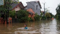 Meski berbahaya, mereka tetap bermain di genangan banjir.