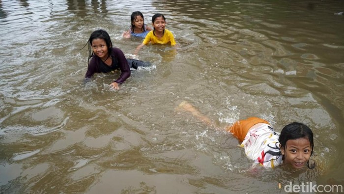 Banjir merendam kawasan Ciledug Indah, Tangerang, Sabtu (16/7/2022). Banjir ini justru jadi tempat bermain anak-anak. Ini potretnya.