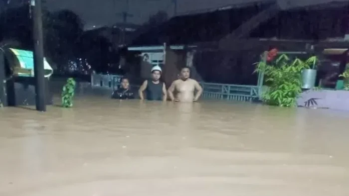 Sejumlah warga berjalan melewati genangan banjir di Perumahan Bumi Pesanggrahan Indah (BPI) di Desa Cilebut Barat, Sukaraja, Kabupaten Bogor, Jawa Barat, Jumat (15/7/2022) malam.