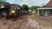 Proses penyingkiran lumpur tebal sisa banjir bandang di jalan desa. (Foto: Dian Utoro Aji/detikJateng)